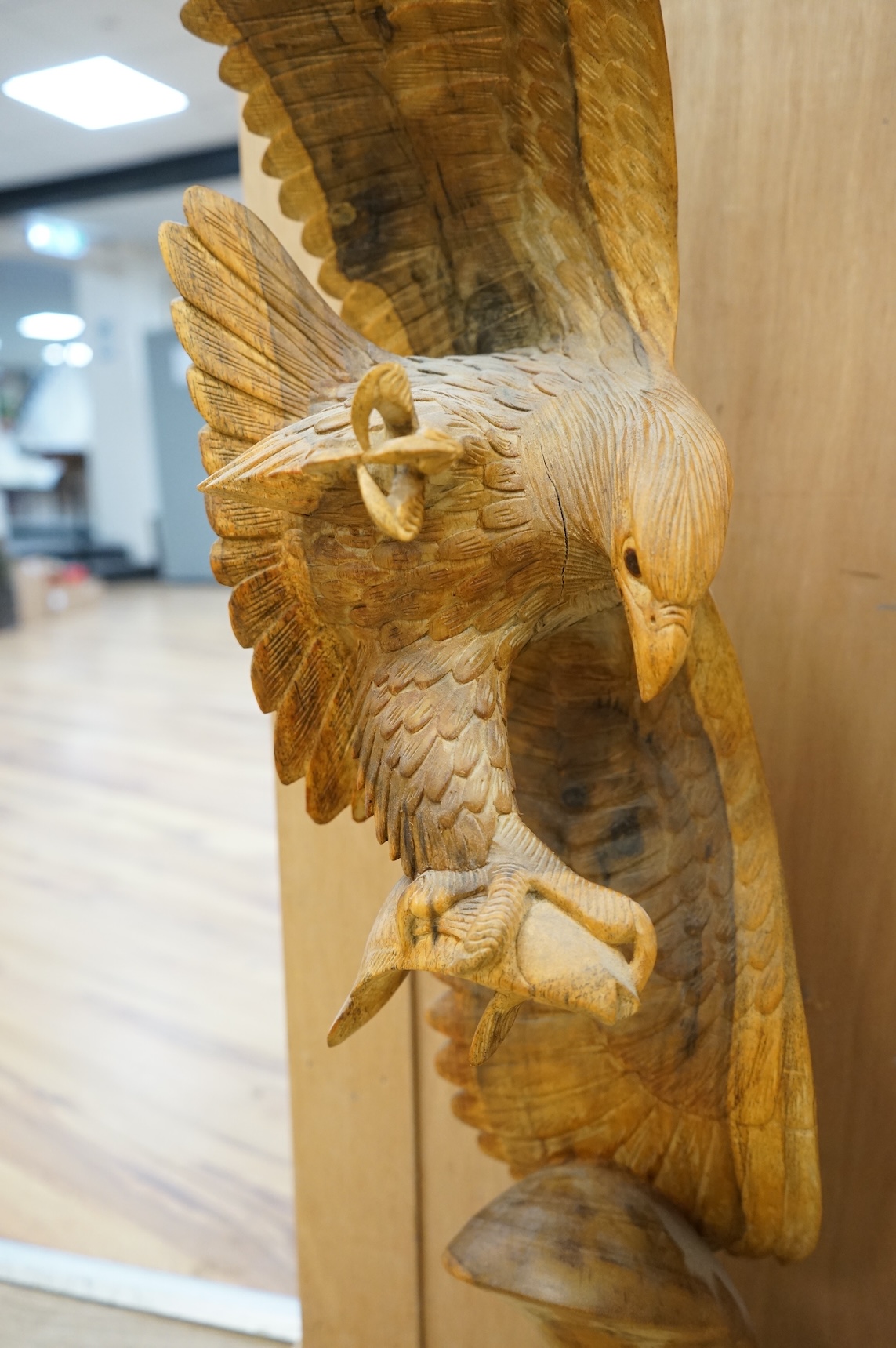 A large carved wood sculpture of an eagle and prey, 102cm high